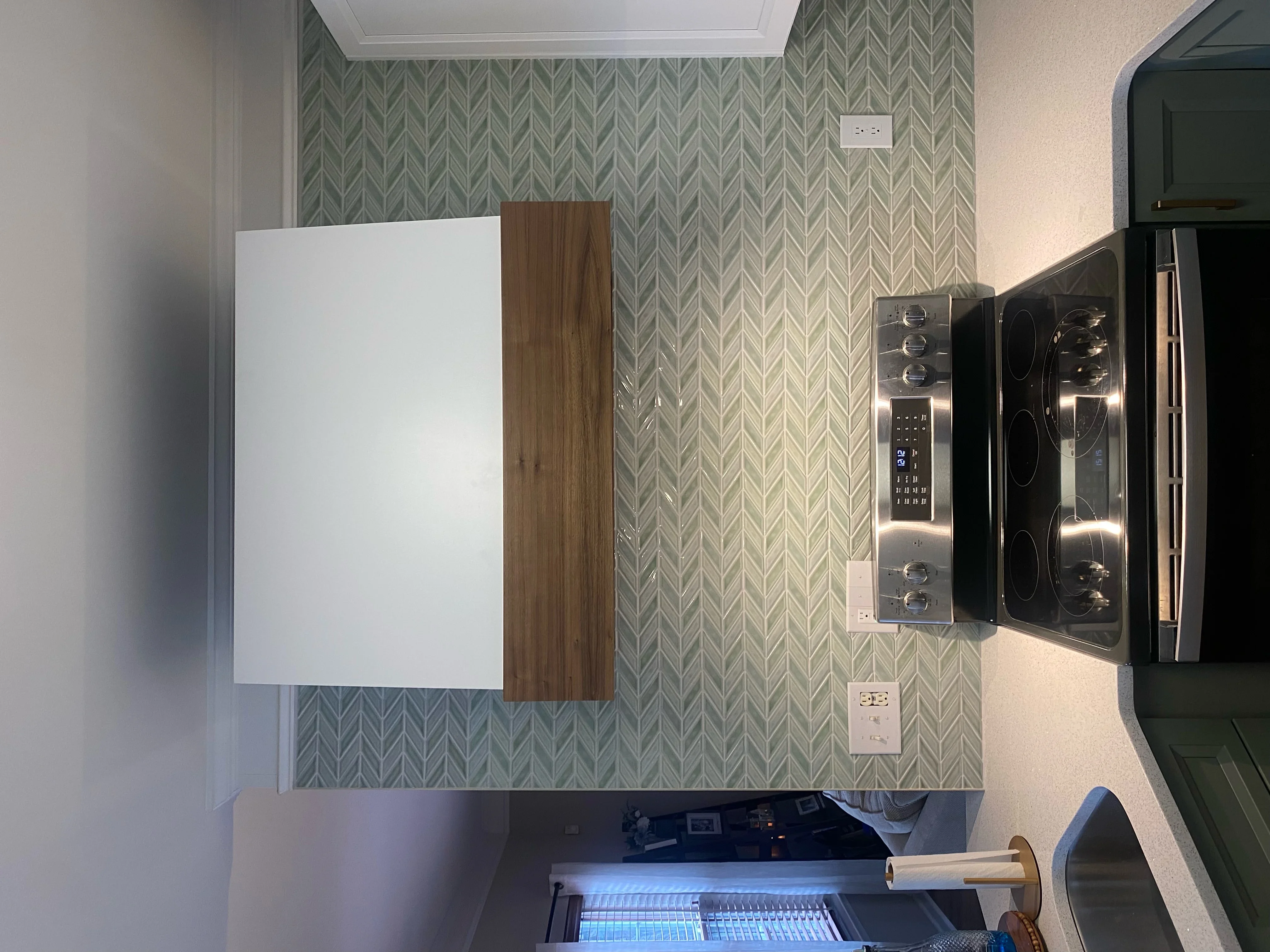 Kitchen with herringbone wallpaper, stainless steel double wall oven, and wood accent panel