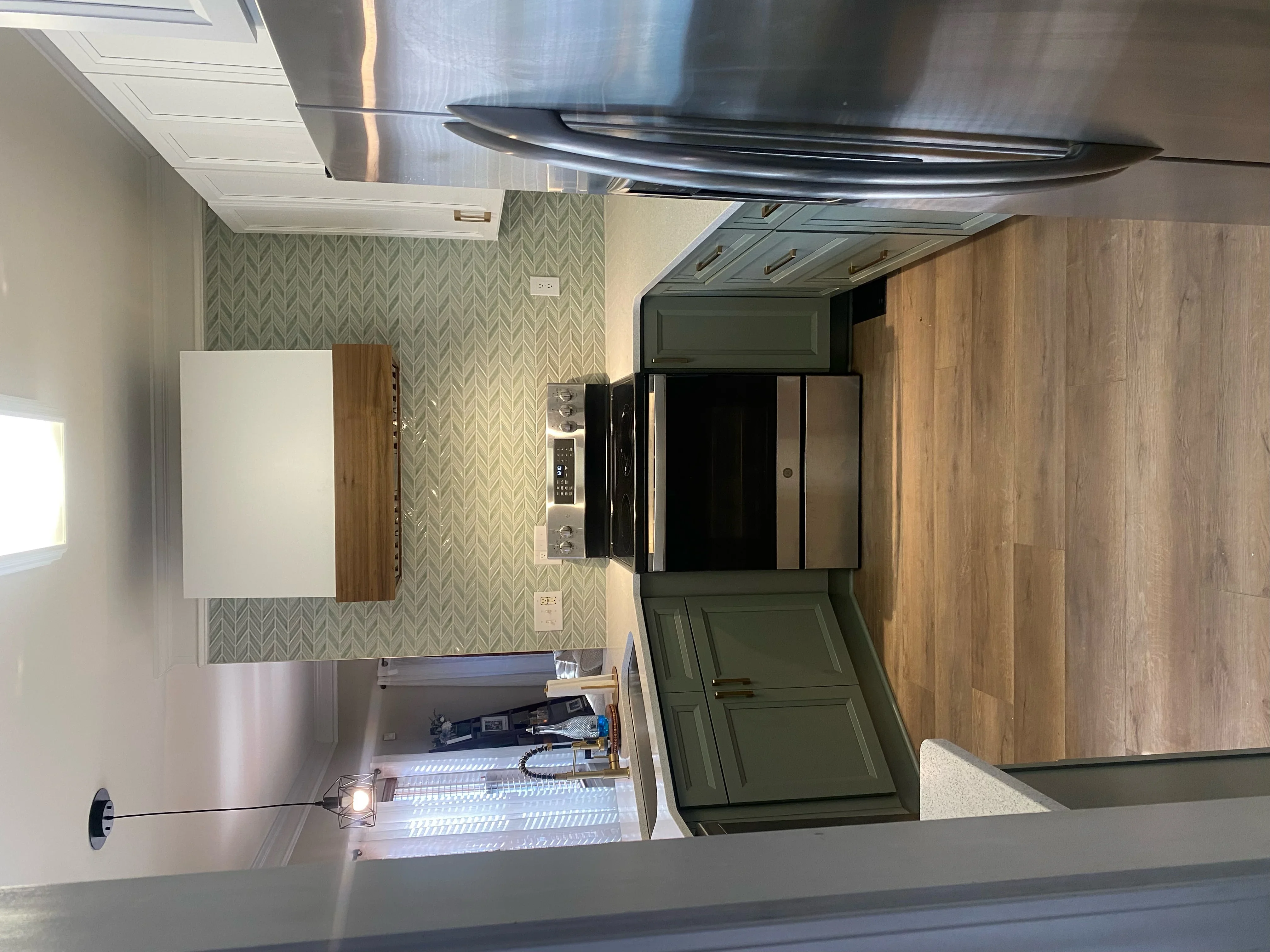 Kitchen remodel with wood cabinetry, geometric wallpaper, stainless steel hood, and herringbone tile flooring