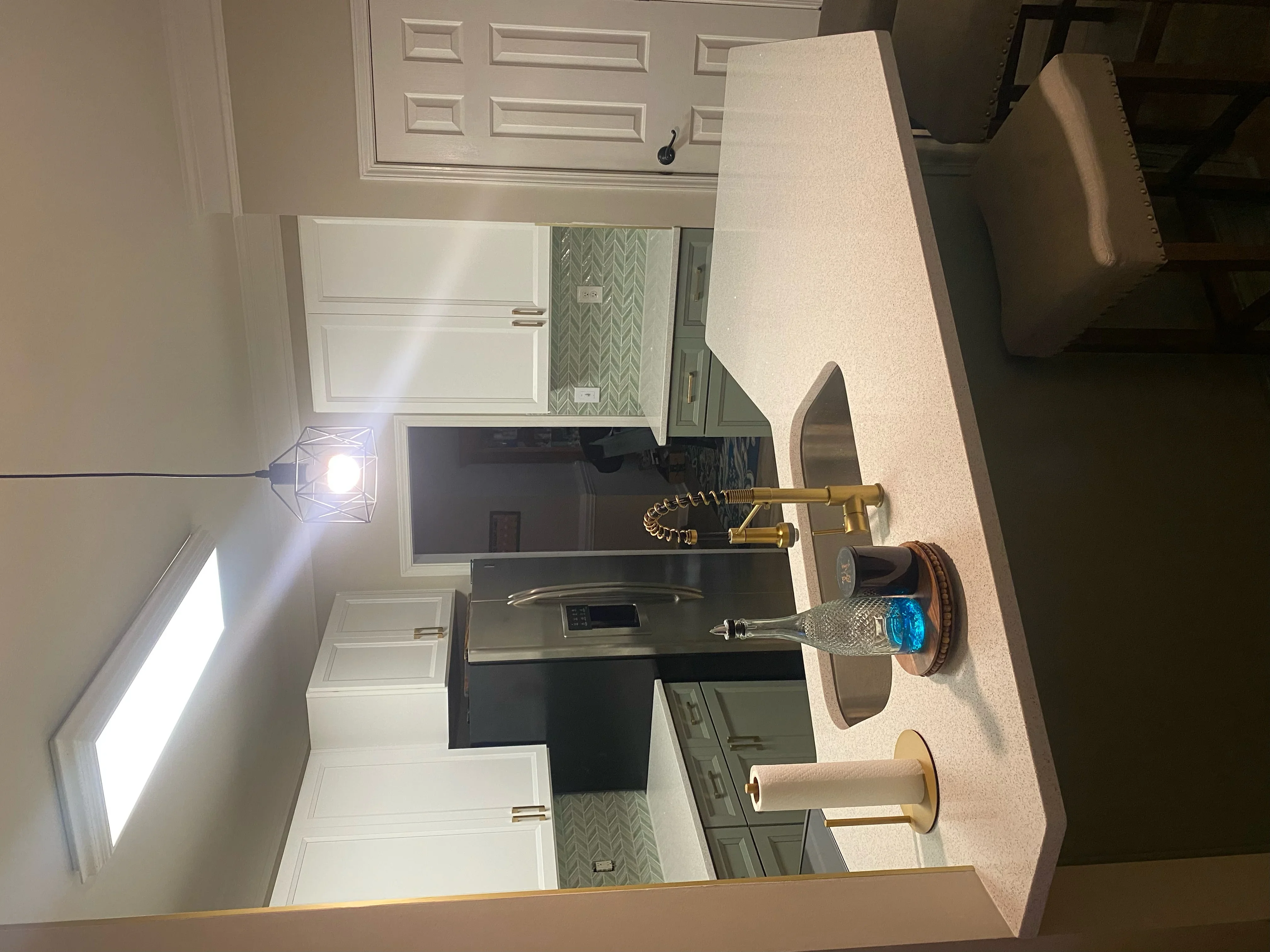 White cabinetry, black quartz counters, geometric tile backsplash, recessed lighting in modern kitchen