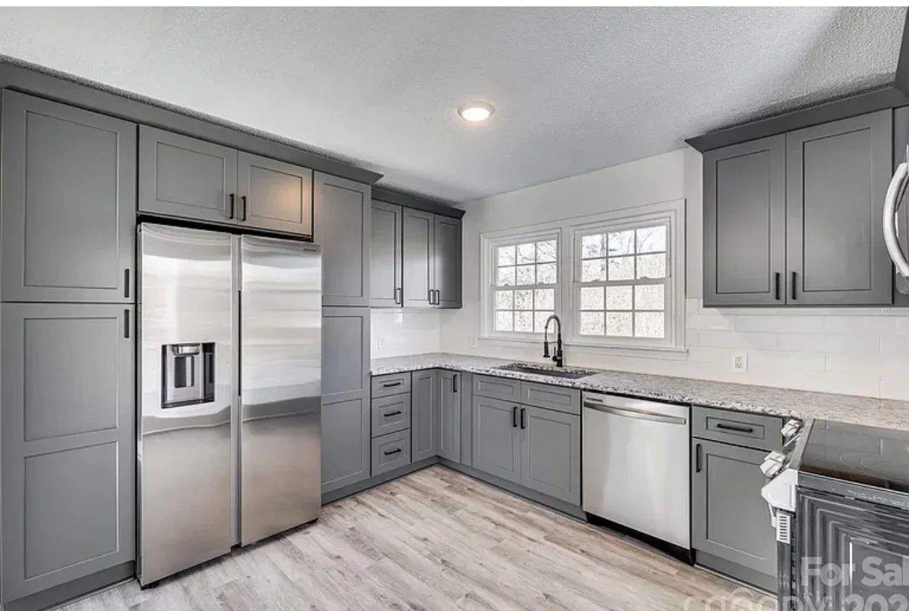 Gray shaker cabinets, granite countertops, stainless steel appliances, white tile backsplash